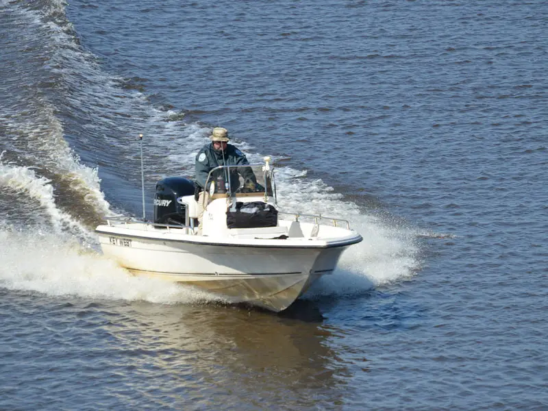 A speedboat going fast across a lake.