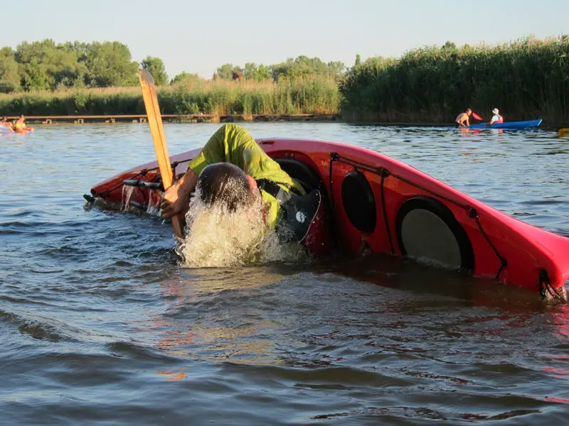A man practicing an Eskimo roll in a kayak