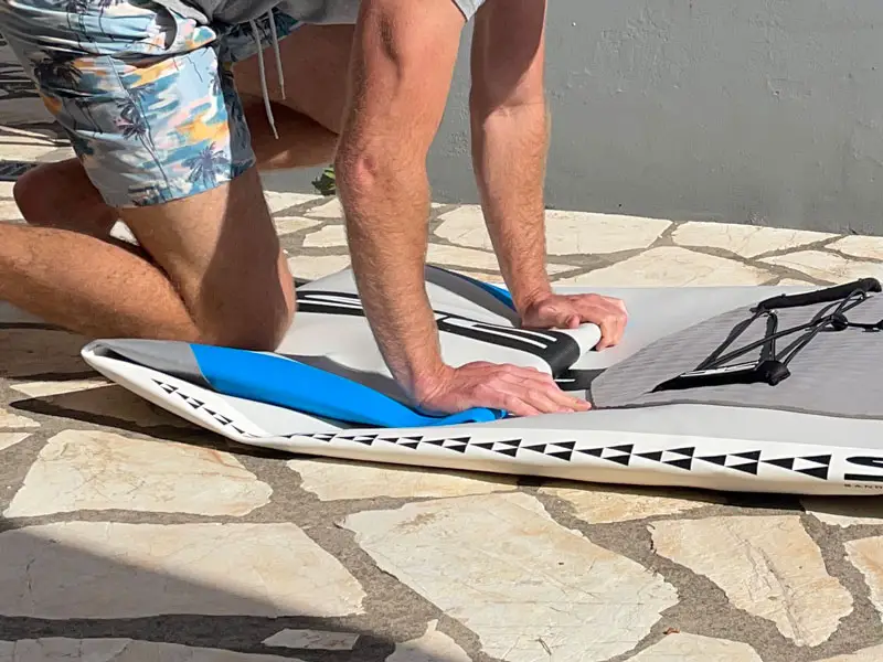 Folding a paddle board from the front to remove the air