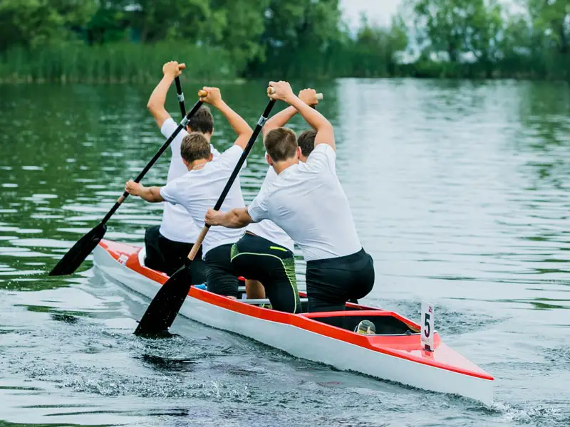 Four men paddling a racing canoe.